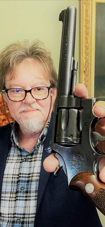 author holding up smith & wesson