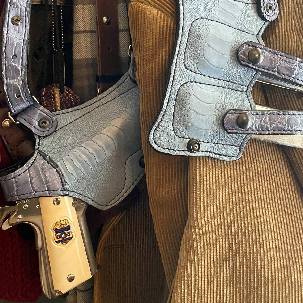 Government Model Colt in shoulder holster hanging on rack