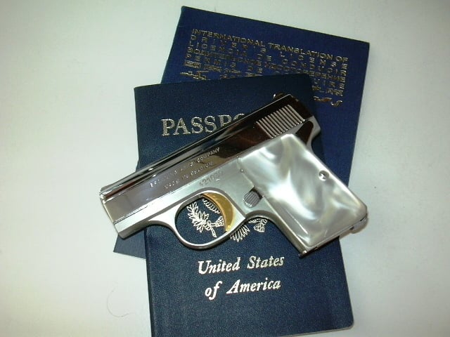 Baby Browning .25 Caliber Pistol laying on U.S. Passport and International Driver License