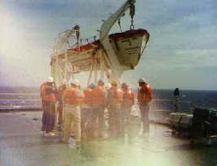 Crew members working with a small boat aboard ship during the return voyage preparations