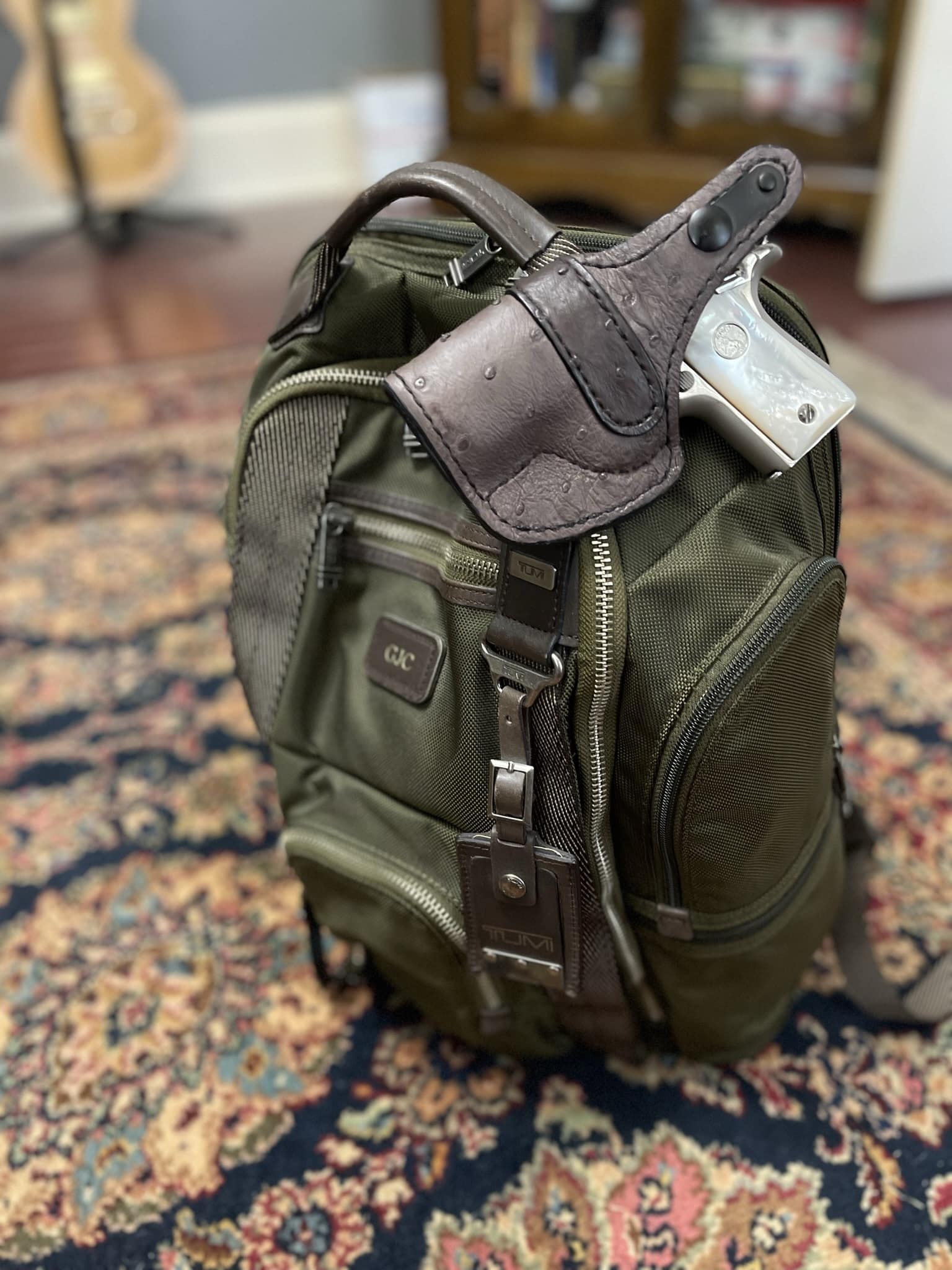 colt handgun attached to backpack