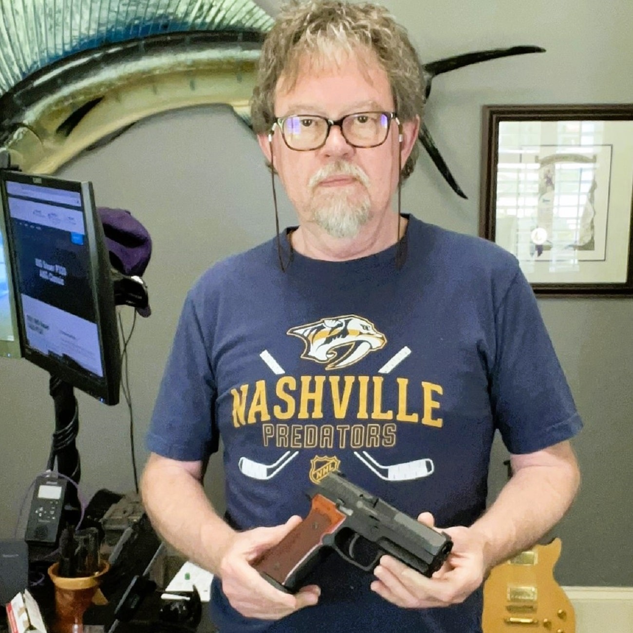 Greg Cook holding a classic target-style semi-automatic pistol