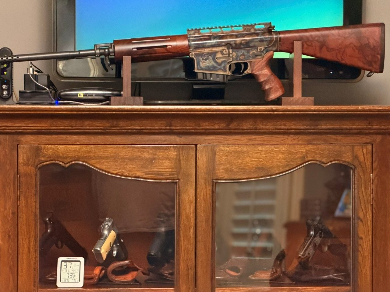 Close view of a Turnbull TAR-40 rifle display with cabinet below