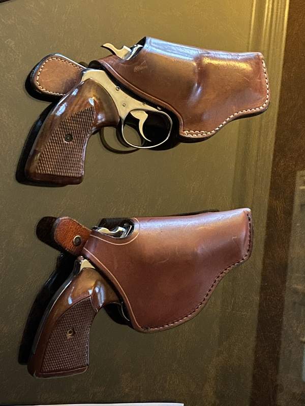 pair of Colt Cobras, one in a holster with trigger guard and one in a holster without trigger guard