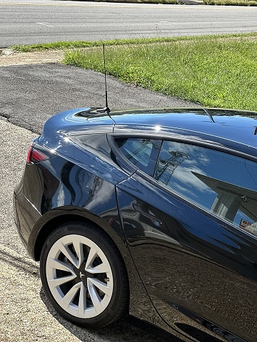 magnet mount citizens band antenna on the trunk of a Tesla Model 3