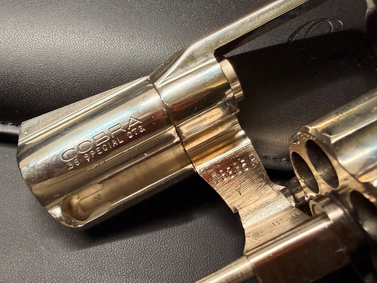 Close view of Colt Cobra serial number and barrel rollmark during inspection