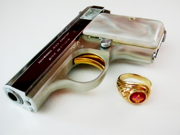 baby browning pistol with gold plated trigger next a gold masonic ring