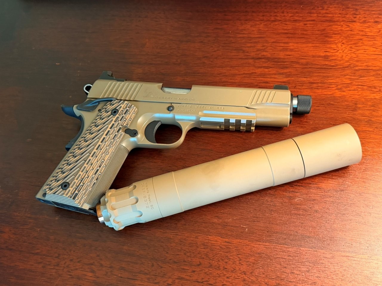 Kimber Desert Warrior with suppressor displayed on marble top