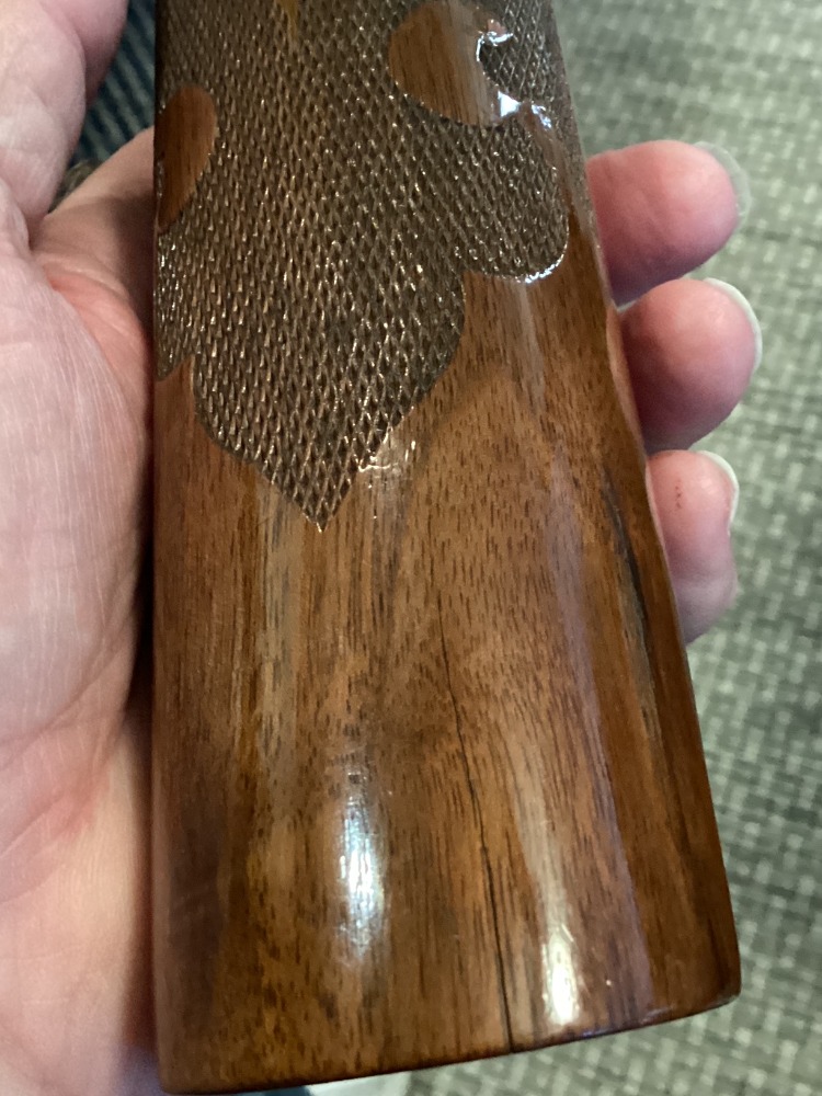 Long split in the wooden forearm below its fleur-de-lis checkering